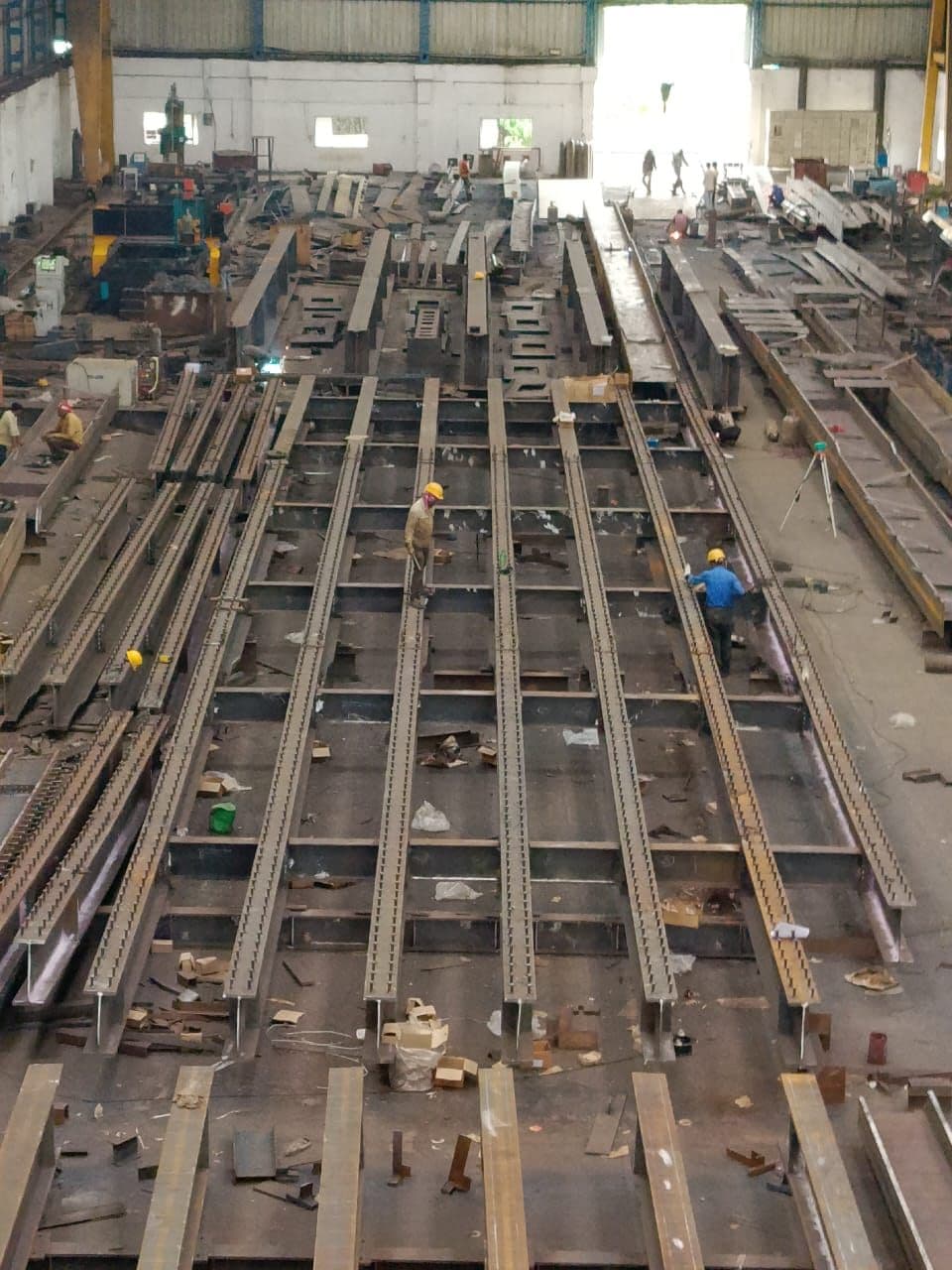Workers assembling plate girders in the fabrication bay