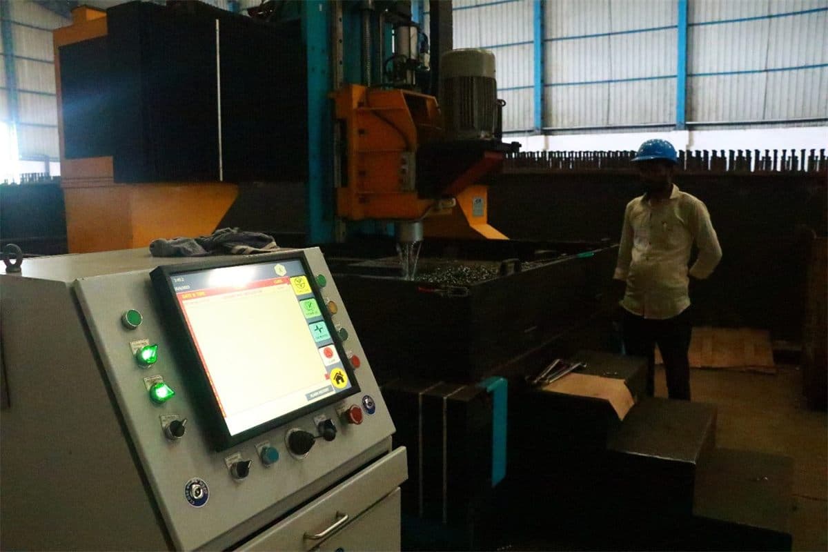 Operator at the CNC drilling machine control panel